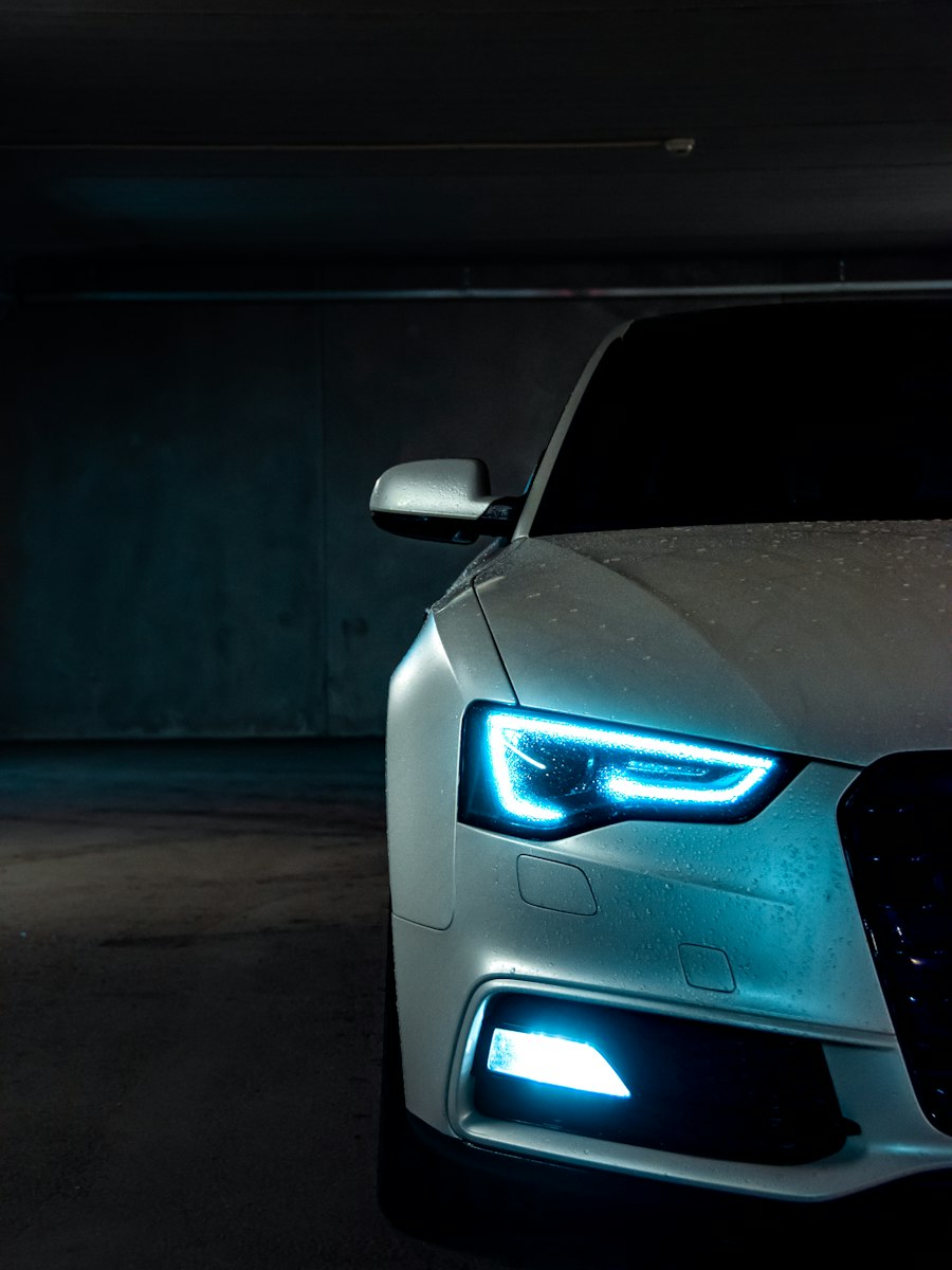 Close-up of a car headlight glowing in the dark.