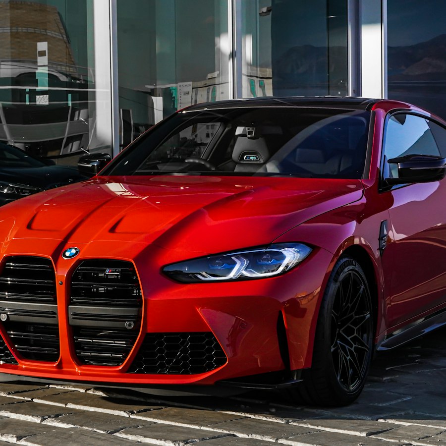 Front of a red sports coupé on a city street.