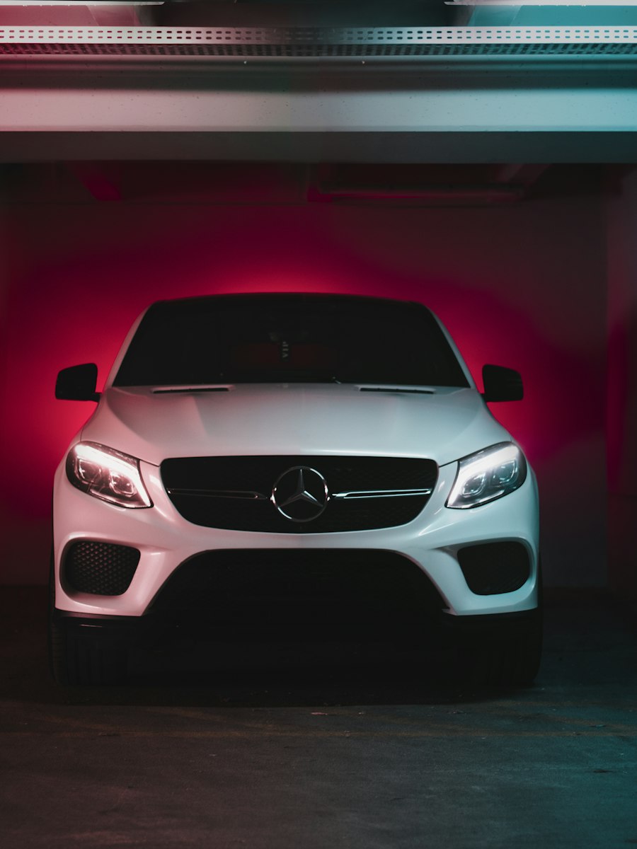 White car in an underground car park washed in red light.