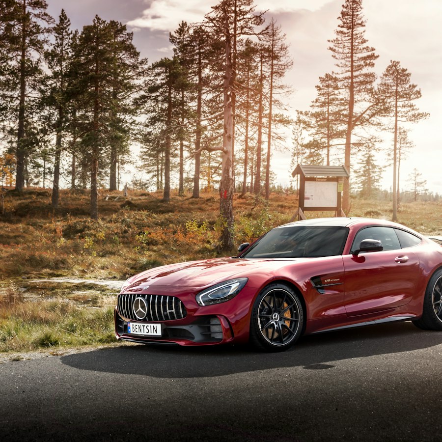 Red grand tourer on an autumn road.