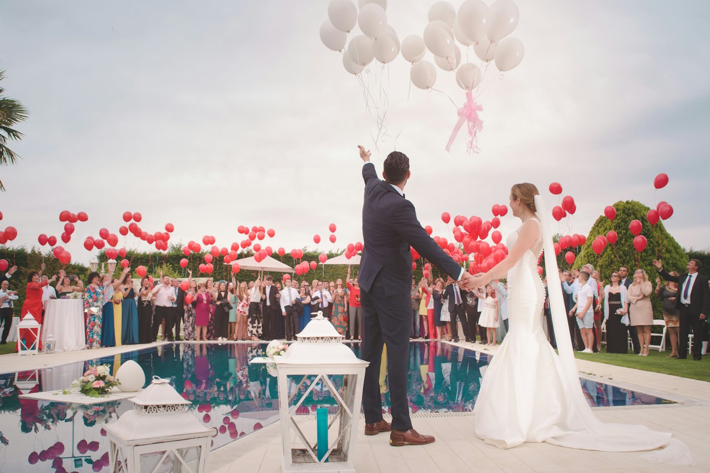 Outdoor celebration with balloons released into the sky.