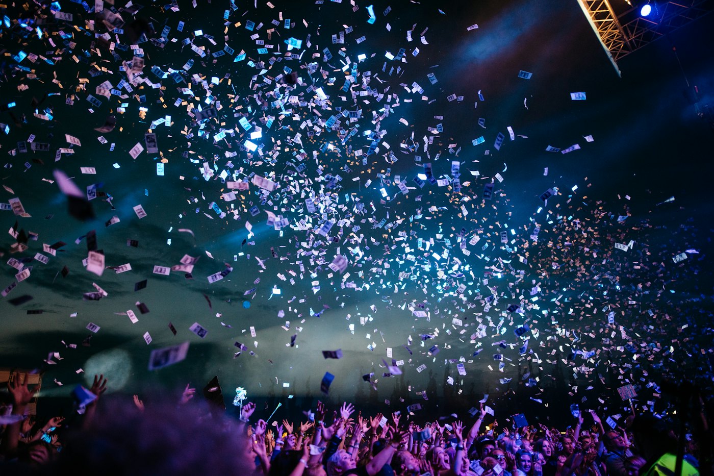 Confetti falling over a crowd at night.