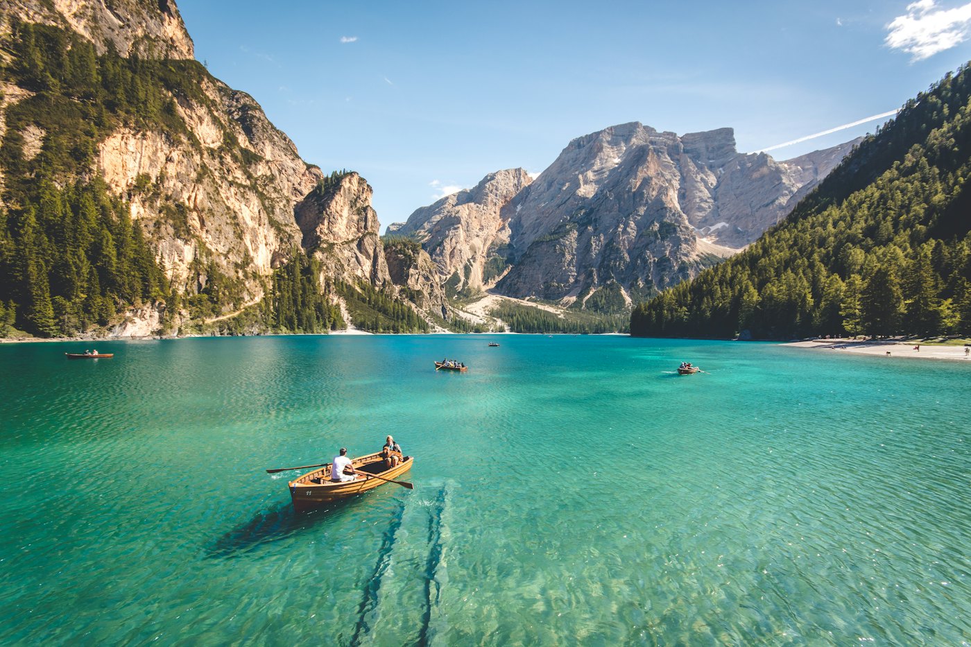 Boat on a still turquoise mountain lake.