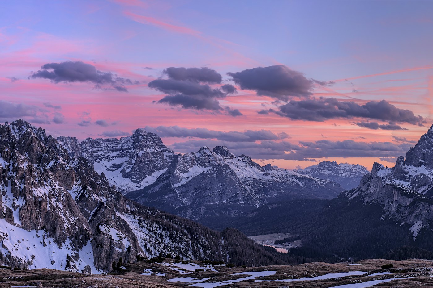 Snow-capped mountains under a pink evening sky.