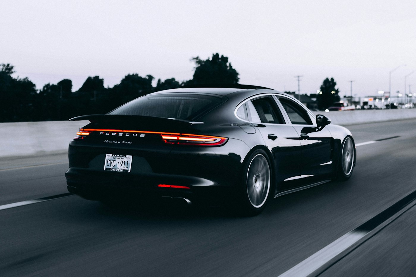 Black saloon photographed rolling from a chase car.