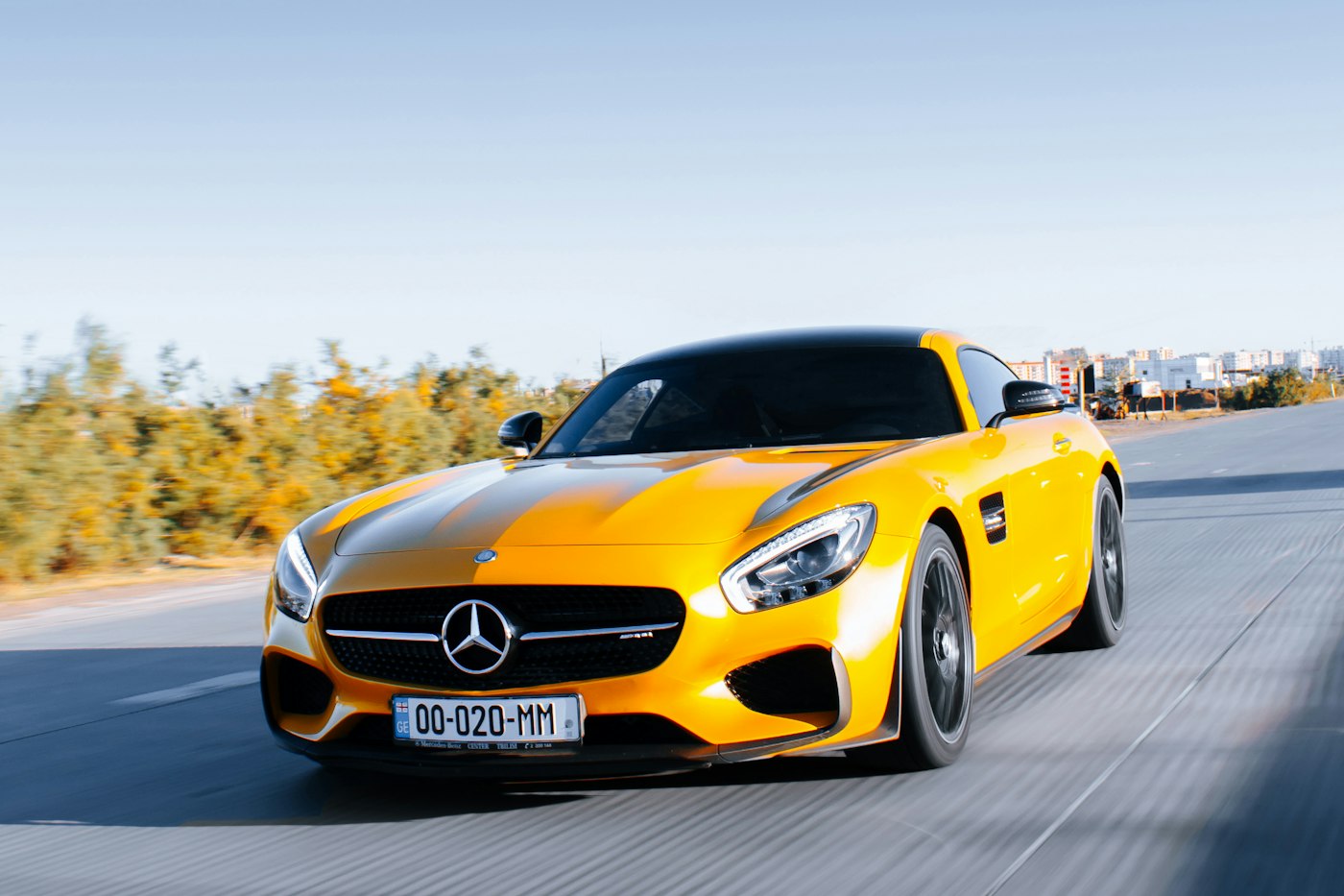 Yellow grand tourer driving on an open road.
