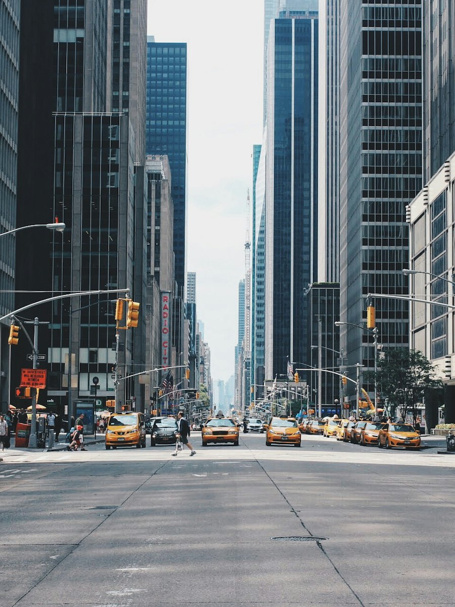 Wide city avenue lined with tall buildings.